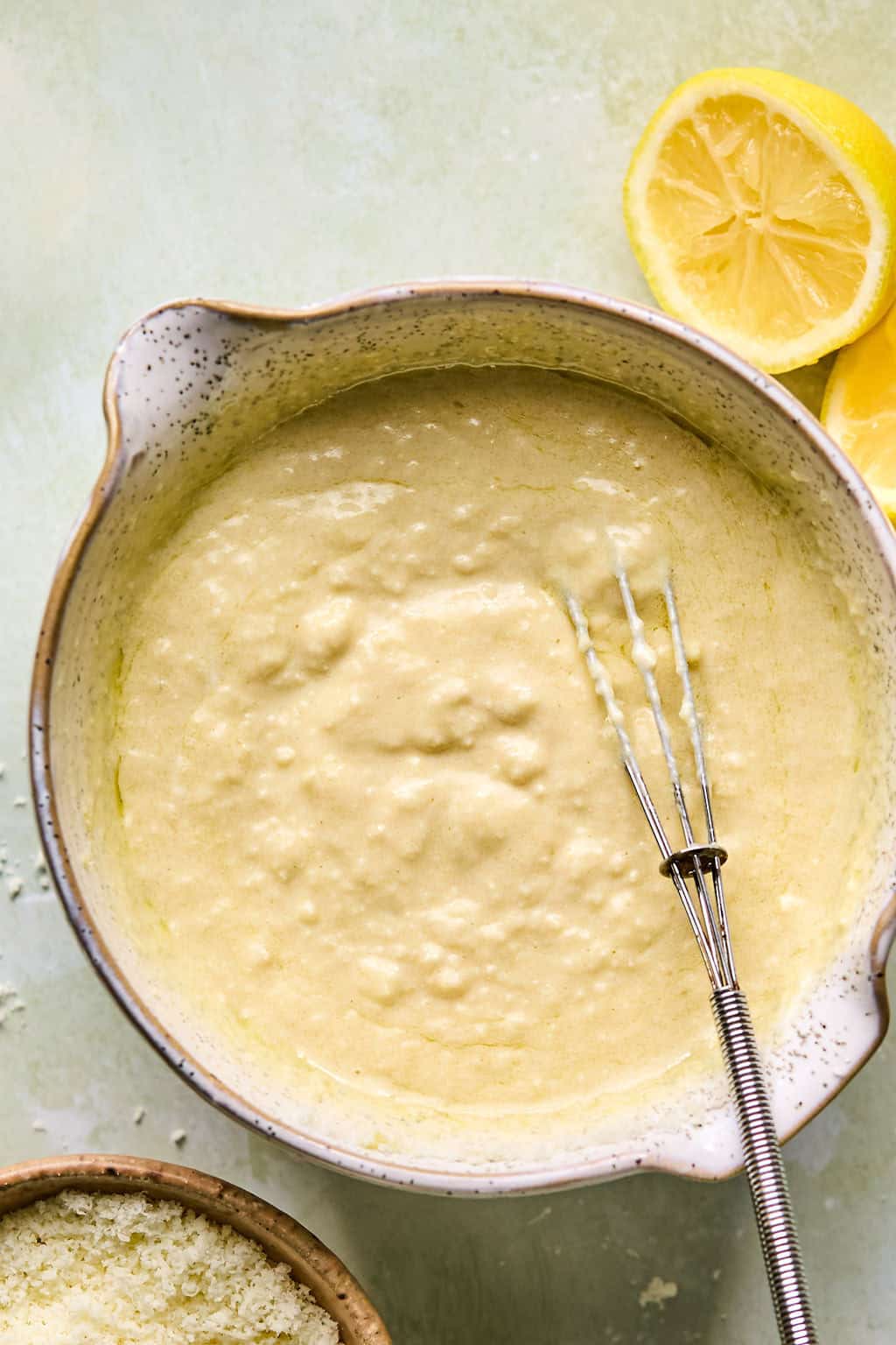 whisking homemade caesar dressing in a bowl.