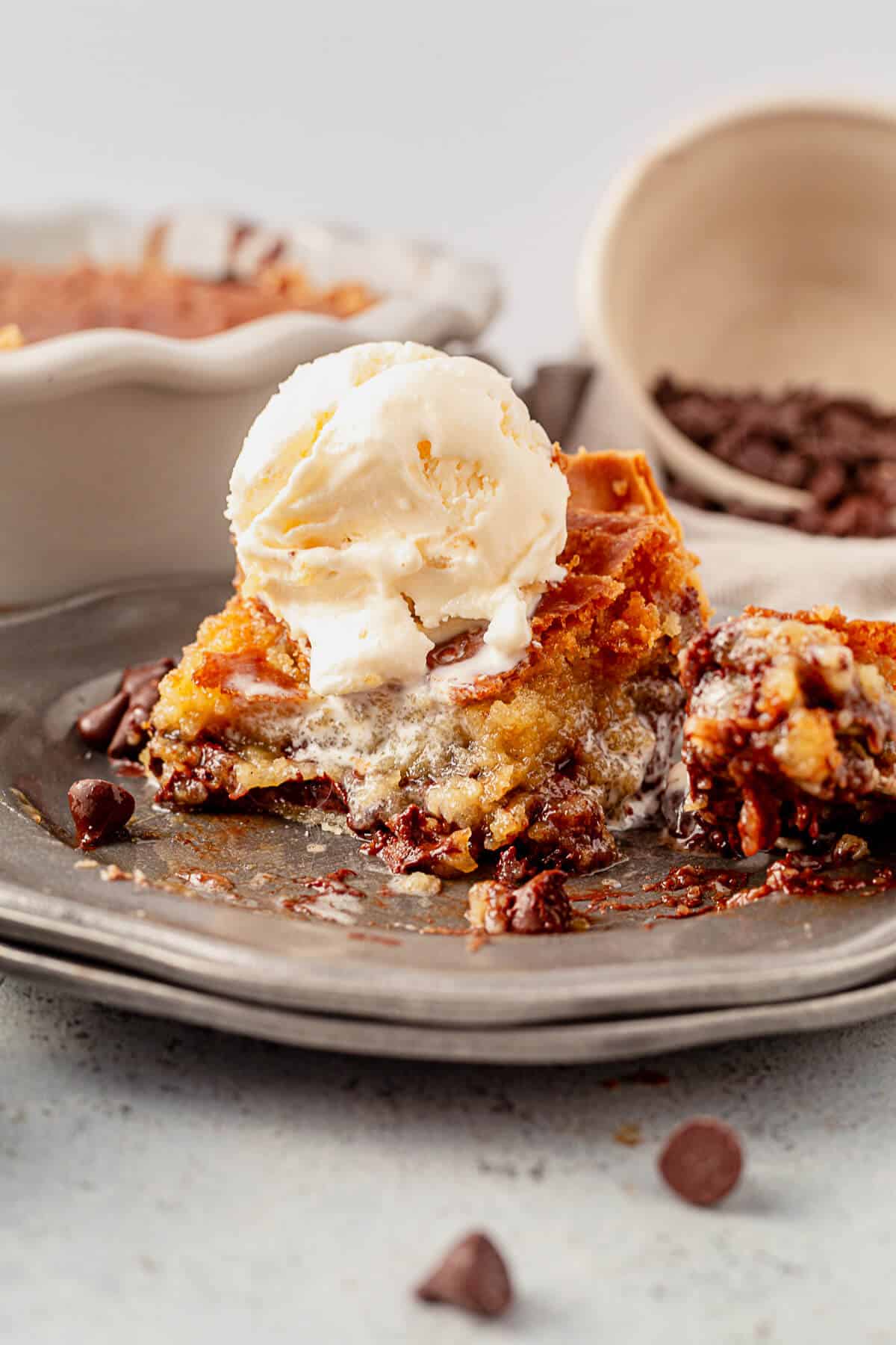 a piece of chocolate chip pie and ice cream on a plate with a bite out of it
