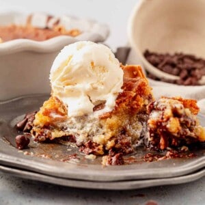 a piece of warm chocolate chip pie with ice cream and a bite taken out