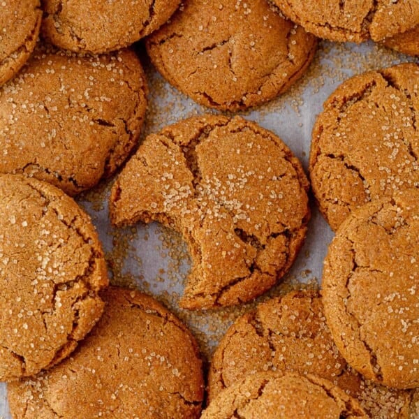 a tray of crackly ginger cookies with one of them missing a bite