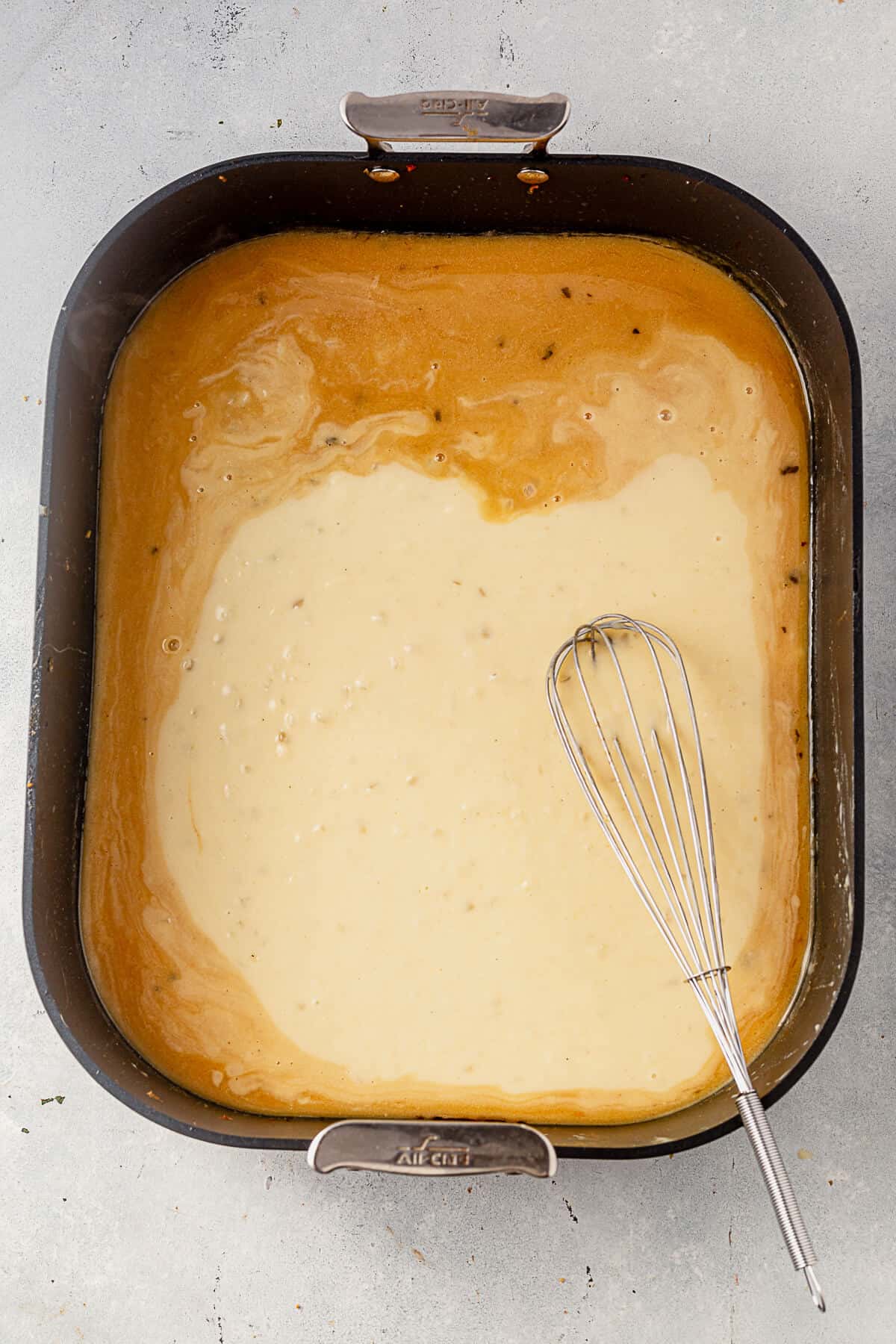 mixing a gravy base into pan drippings from roasted turkey.