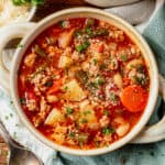 a bowl of ground turkey soup with green beans, white beans, carrots, and potatoes