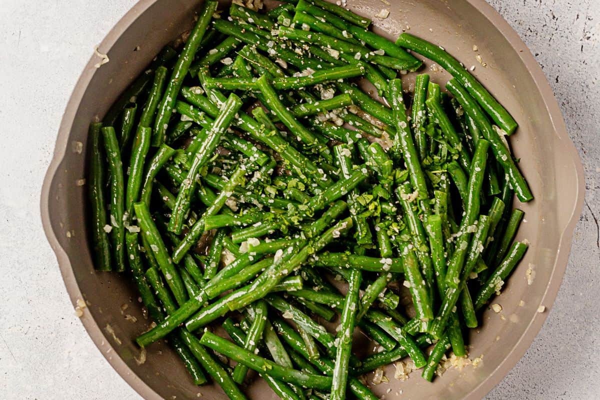 haricot verts sauteed in shallots and butter in a pan