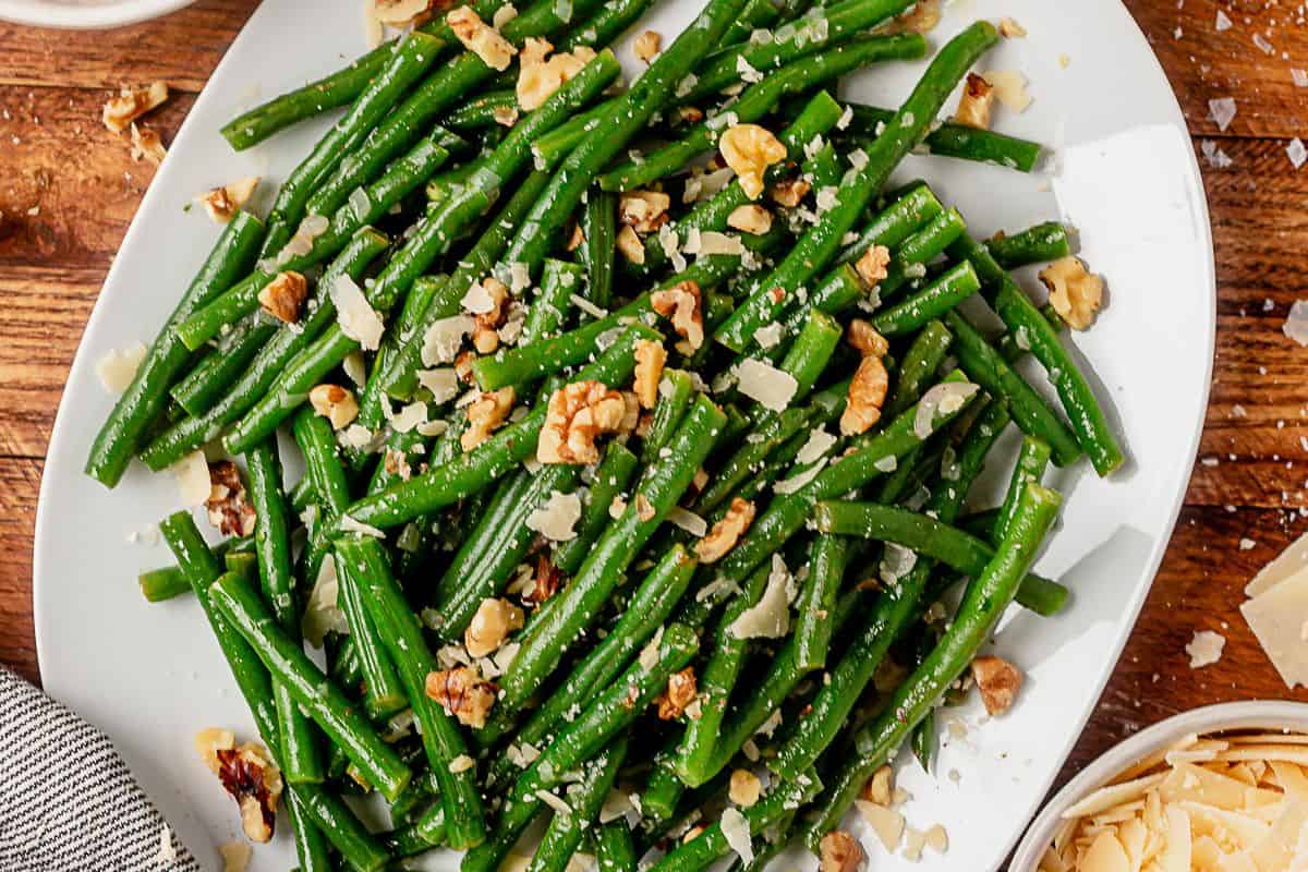 haricot verts on a serving plate with parmesan and walnuts