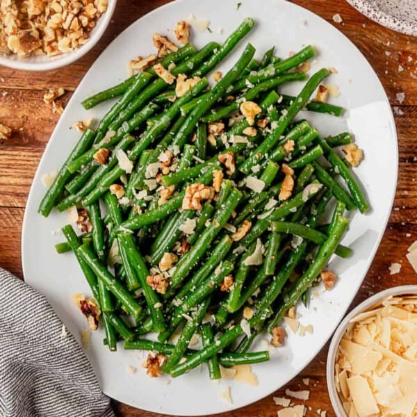 parmesan cheese on top of a plate of haricot verts