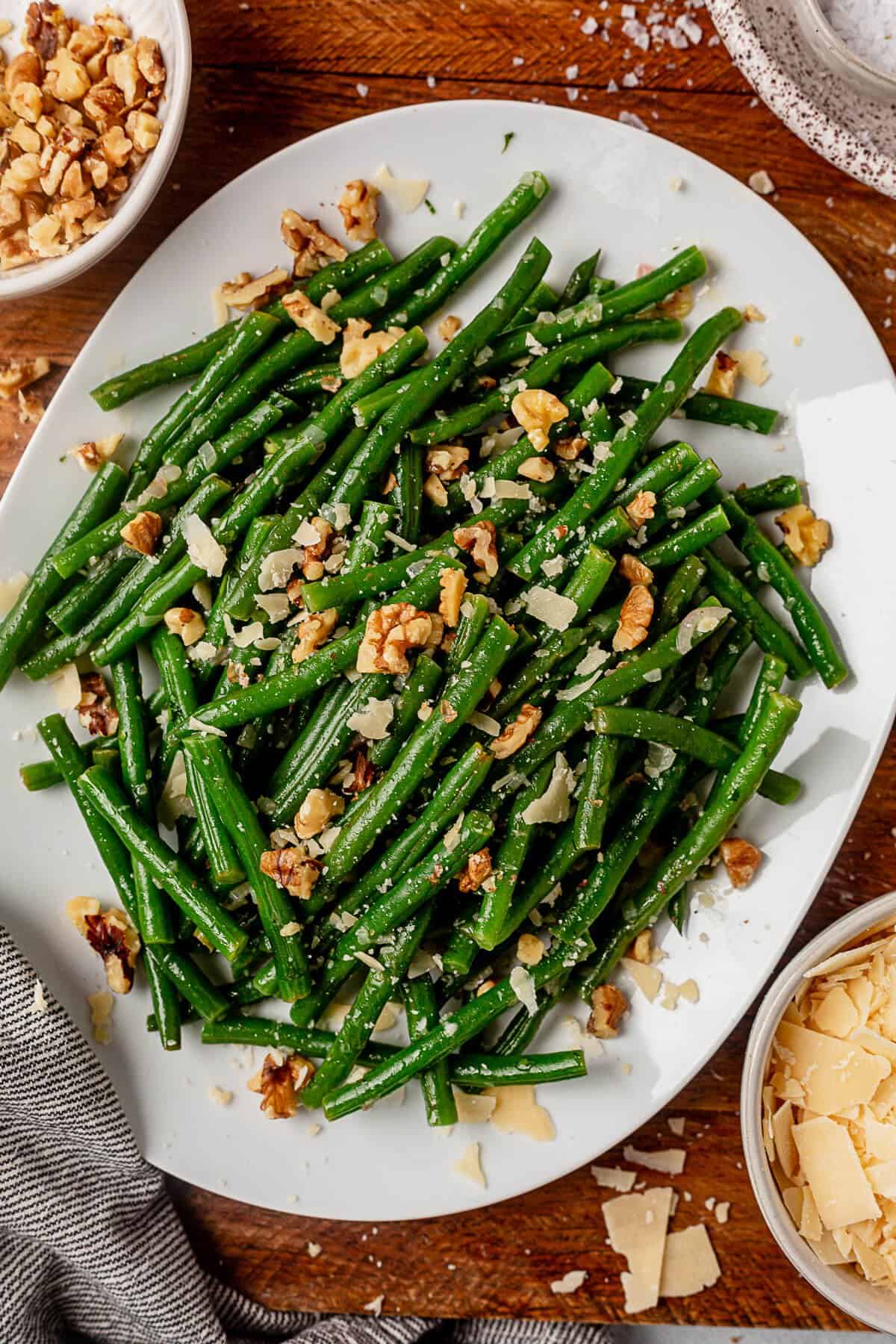 a plate of haricot verts with parmesan cheese on top