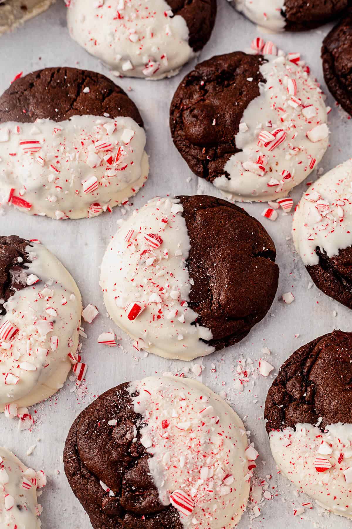 freshly baked peppermint bark cookies covered halfway with white chocolate and crushed candy cane
