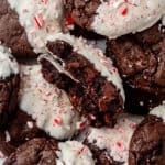 a peppermint bark cookie broken in half on top of a pile of more cookies