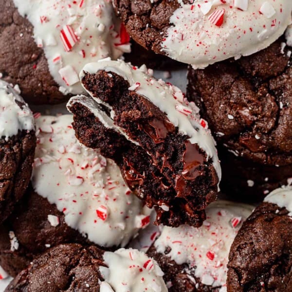 a peppermint bark cookie broken in half on top of a pile of more cookies