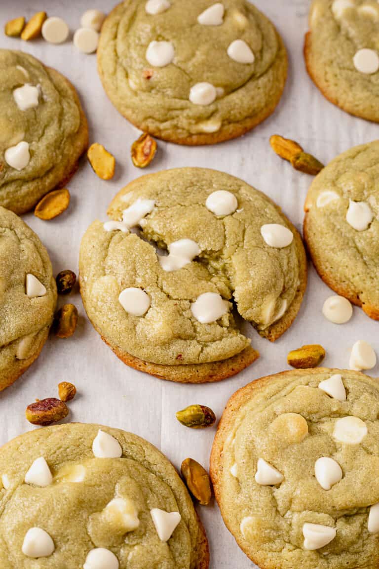 a pistachio pudding cookie being pulled apart with melted white chocolate