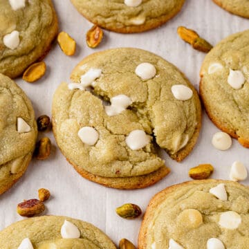 a pistachio pudding cookie broken in half with melted white chocolate