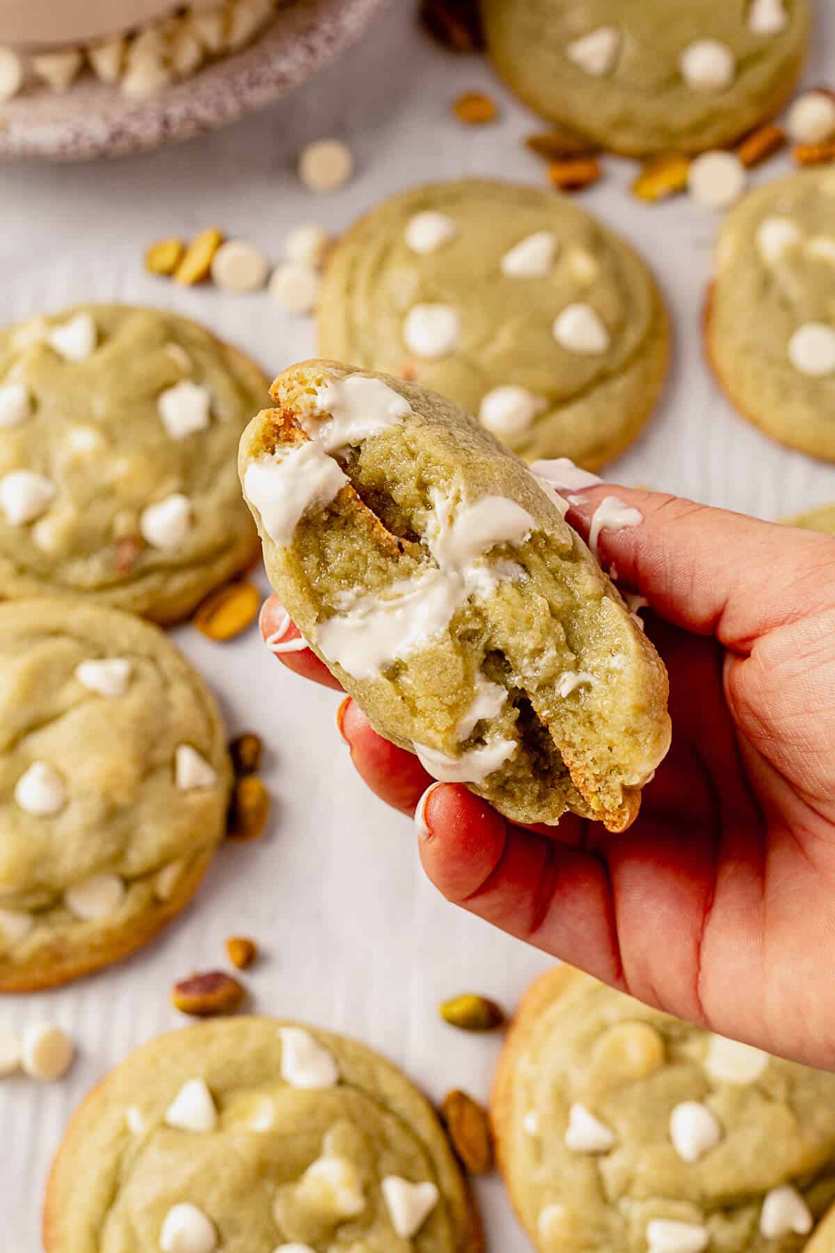 holding two halves of a pistachio pudding cookie