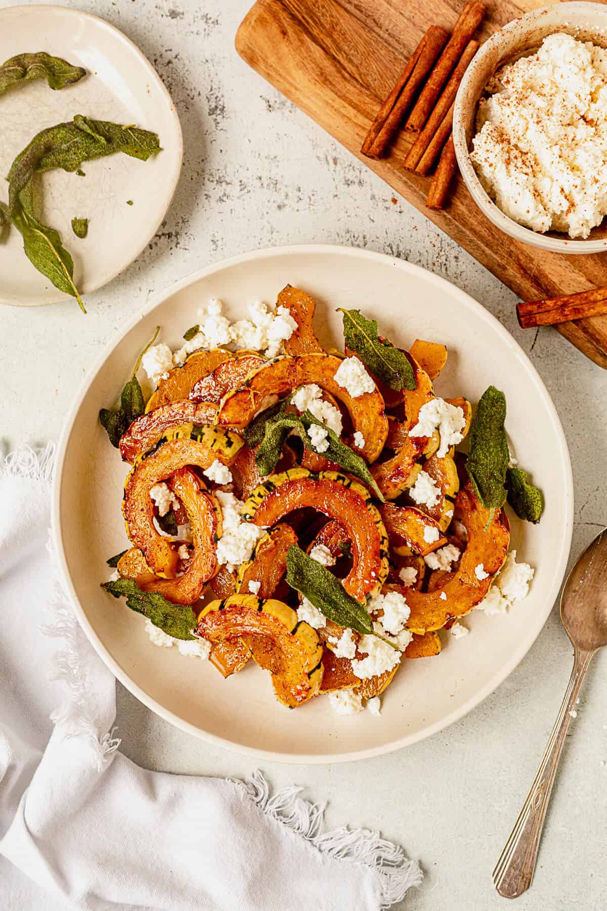 a bowl of roasted delicata squash with fried sage and ricotta