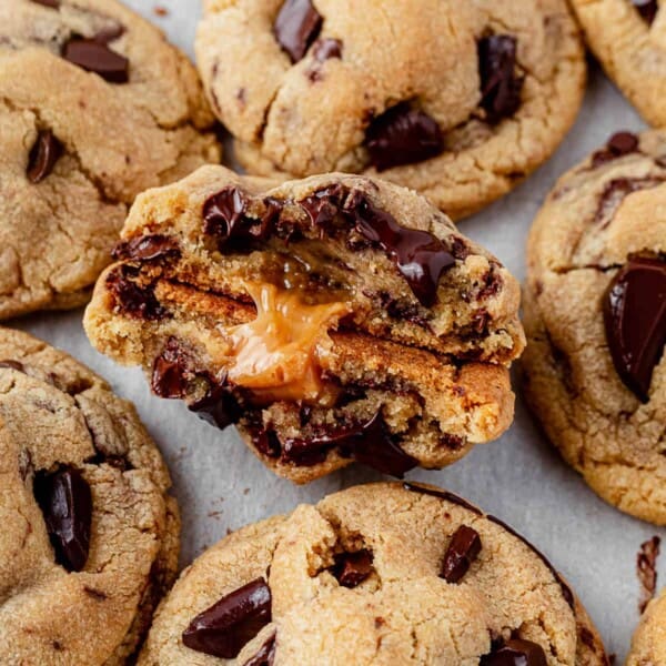 a salted caramel chocolate chip cookie broken in half with gooey caramel and melted chocolate