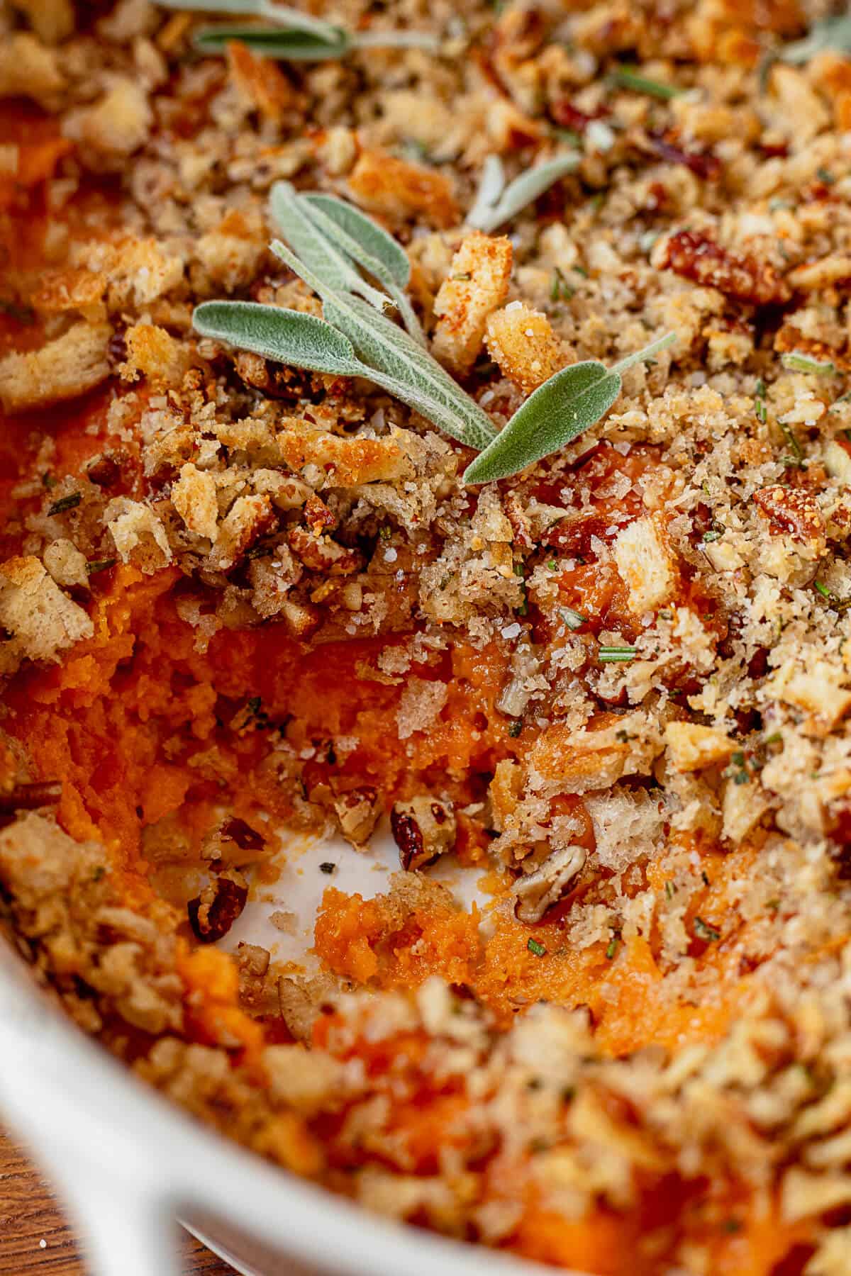 savory sweet potato casserole with a scoop missing so you can see the topping and filling