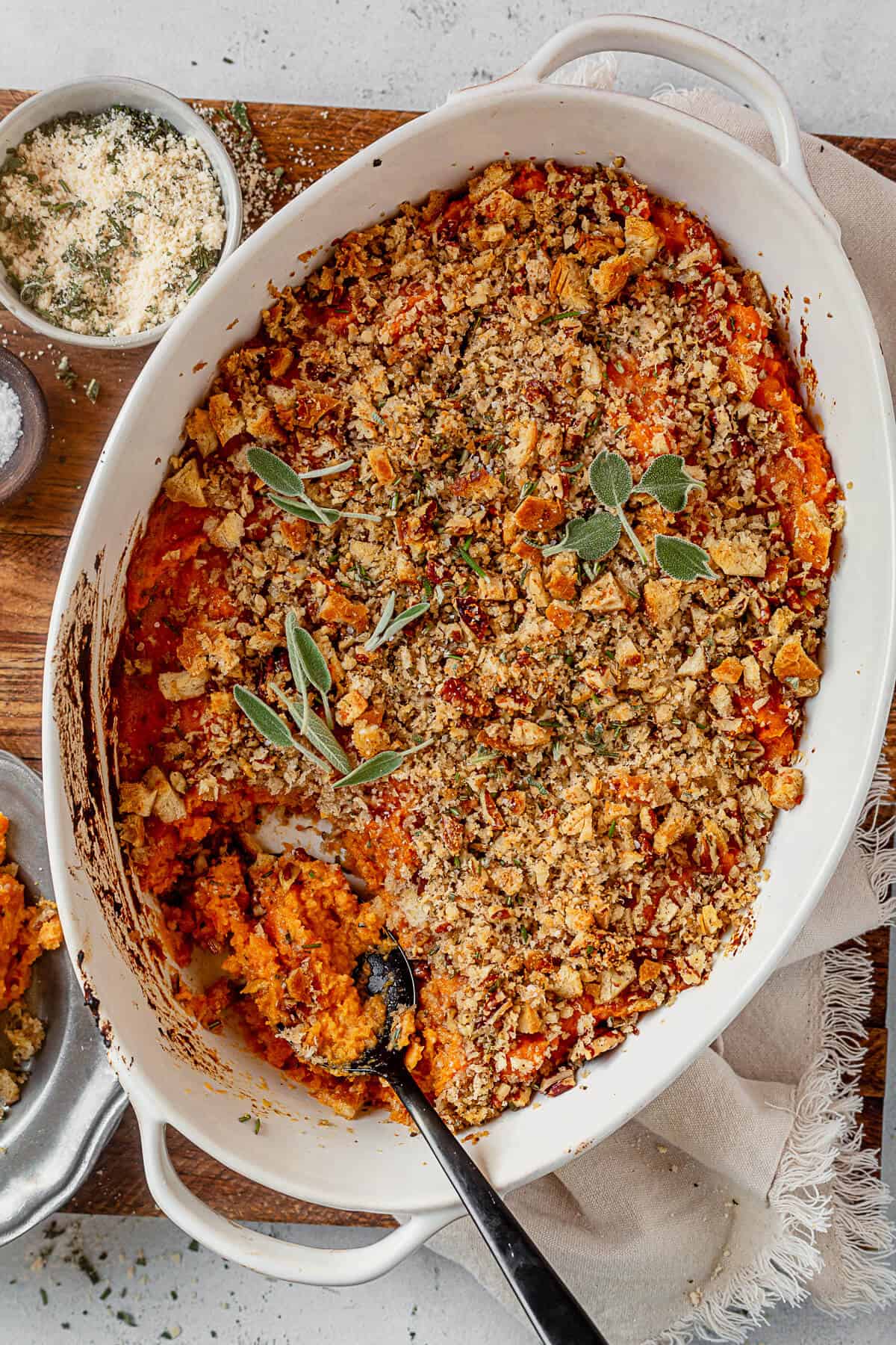 savory sweet potato casserole in a serving dish with a scoop out of it