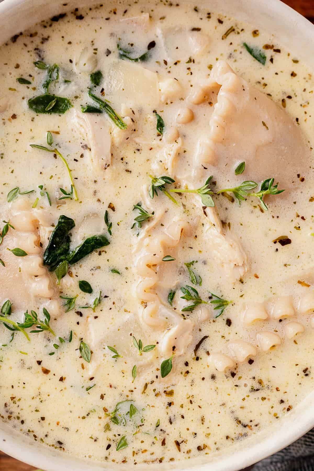 creamy white lasagna soup with fresh thyme in a bowl