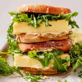 two fluffy egg sandwiches stacked with mayo and arugula