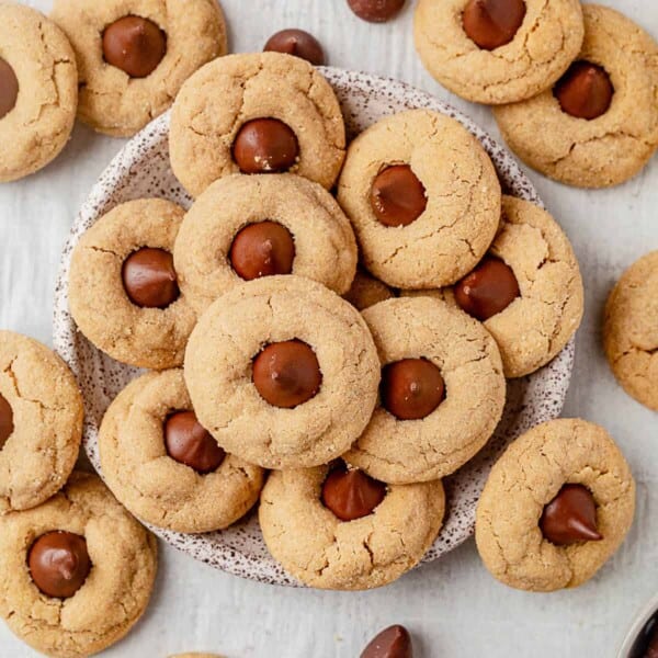 peanut butter blossoms around and on top of a speckled plate