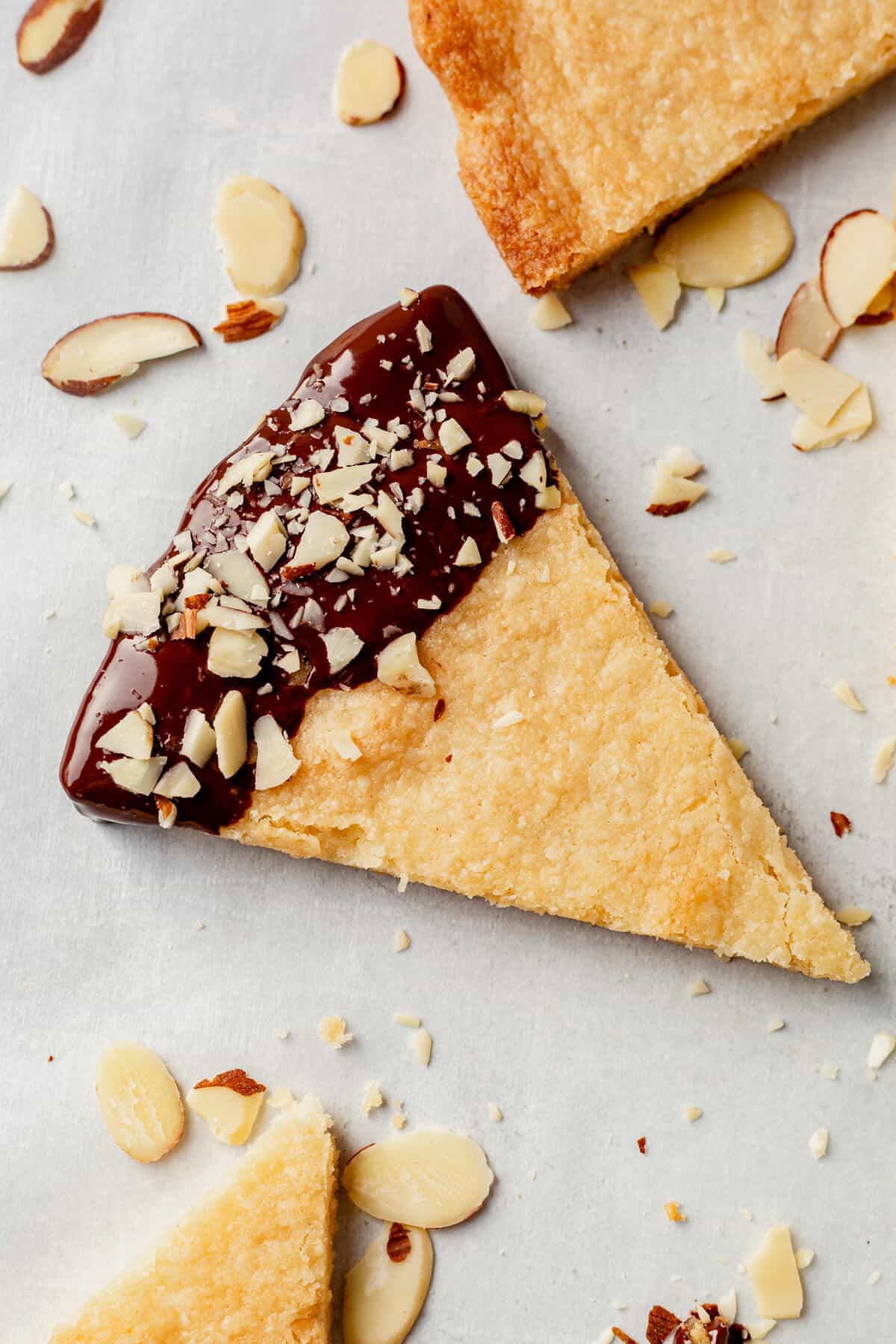 almond shortbread cookie with the end dipped in melted chocolate and sprinkled with crushed almonds