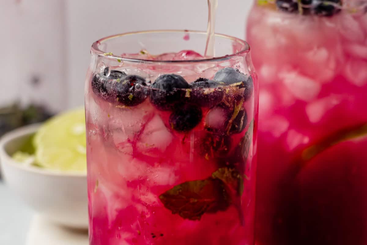 topping a blueberry mojito with club soda