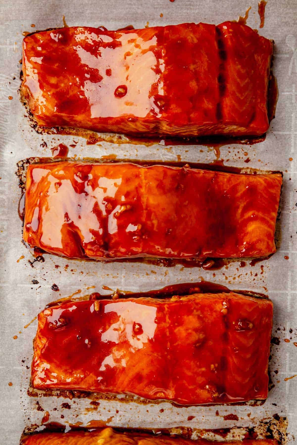 three baked salmon fillets brushed with honey sriracha sauce