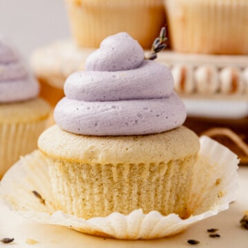 lavender cupcake with light purple butter cream unwrapped on a plate