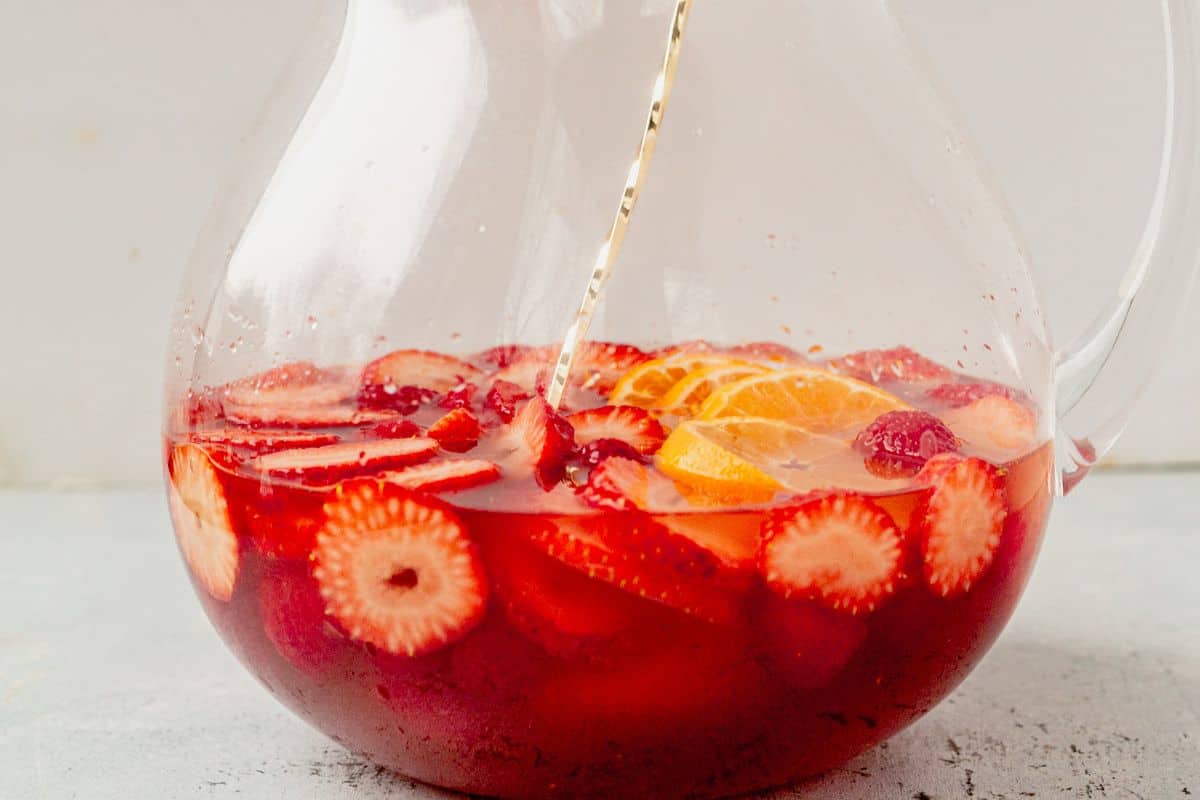 mixing moscato sangria in a pitcher with a spoon