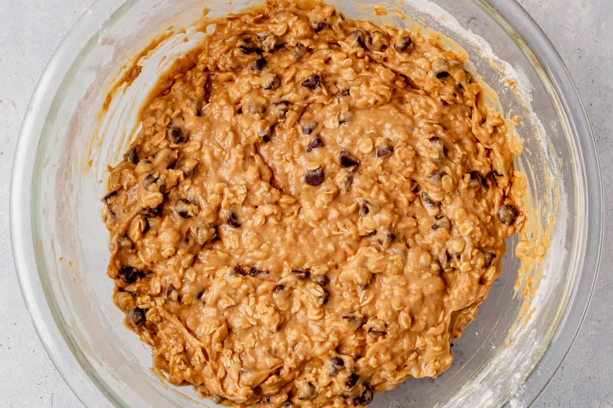 oatmeal chocolate chip muffin batter resting in a mixing bowl