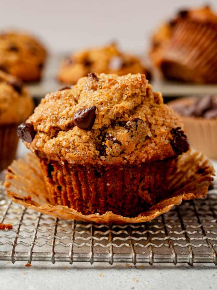 an oatmeal chocolate chip muffin unwrapped on a cooling rack