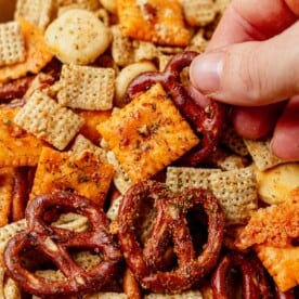 picking ranch chex mix out of a snack bowl
