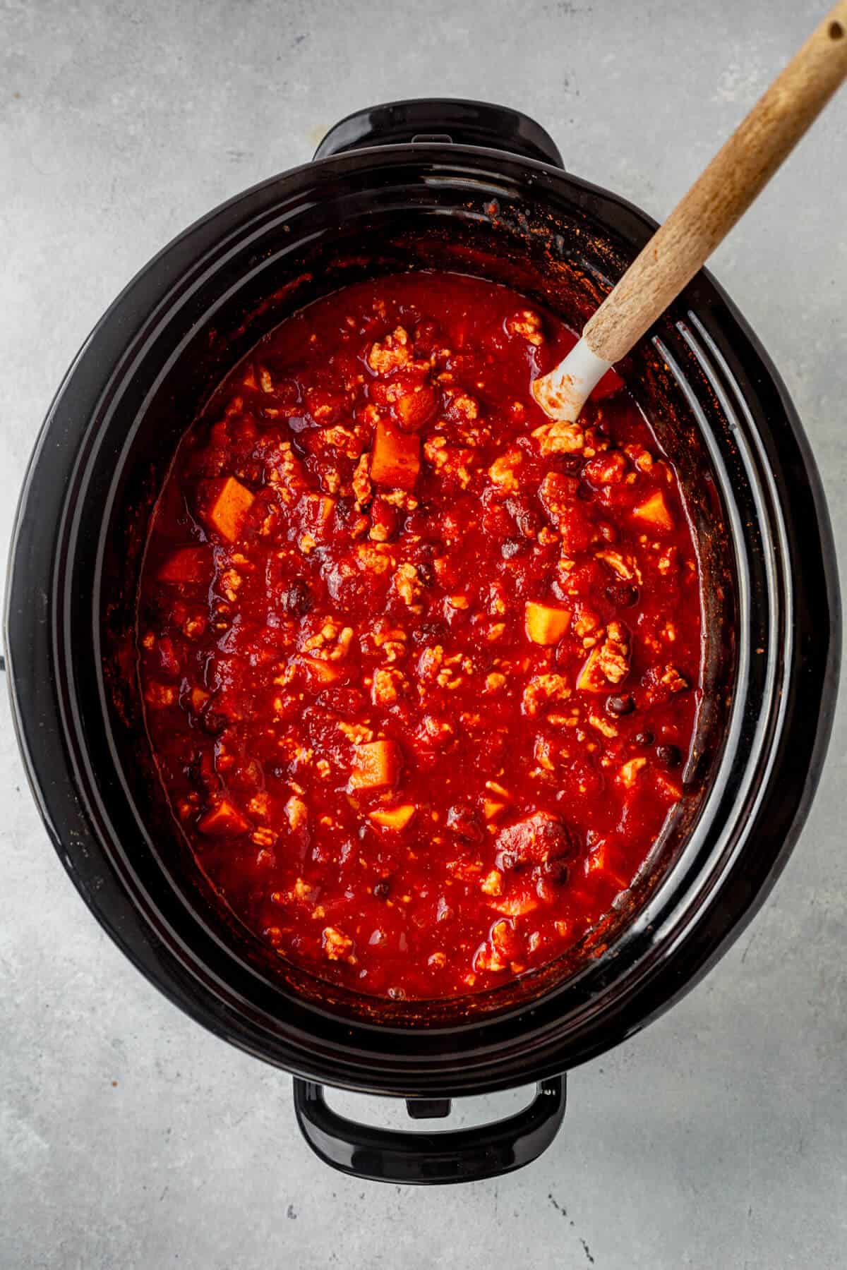slow cooker sweet potato chili with a ladle