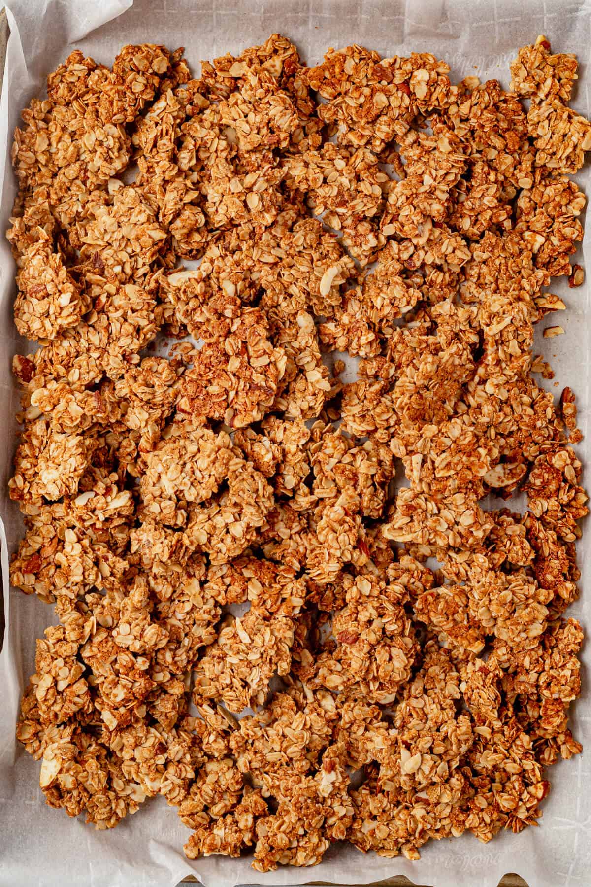 large vanilla almond granola clusters broken up on a cookie sheet