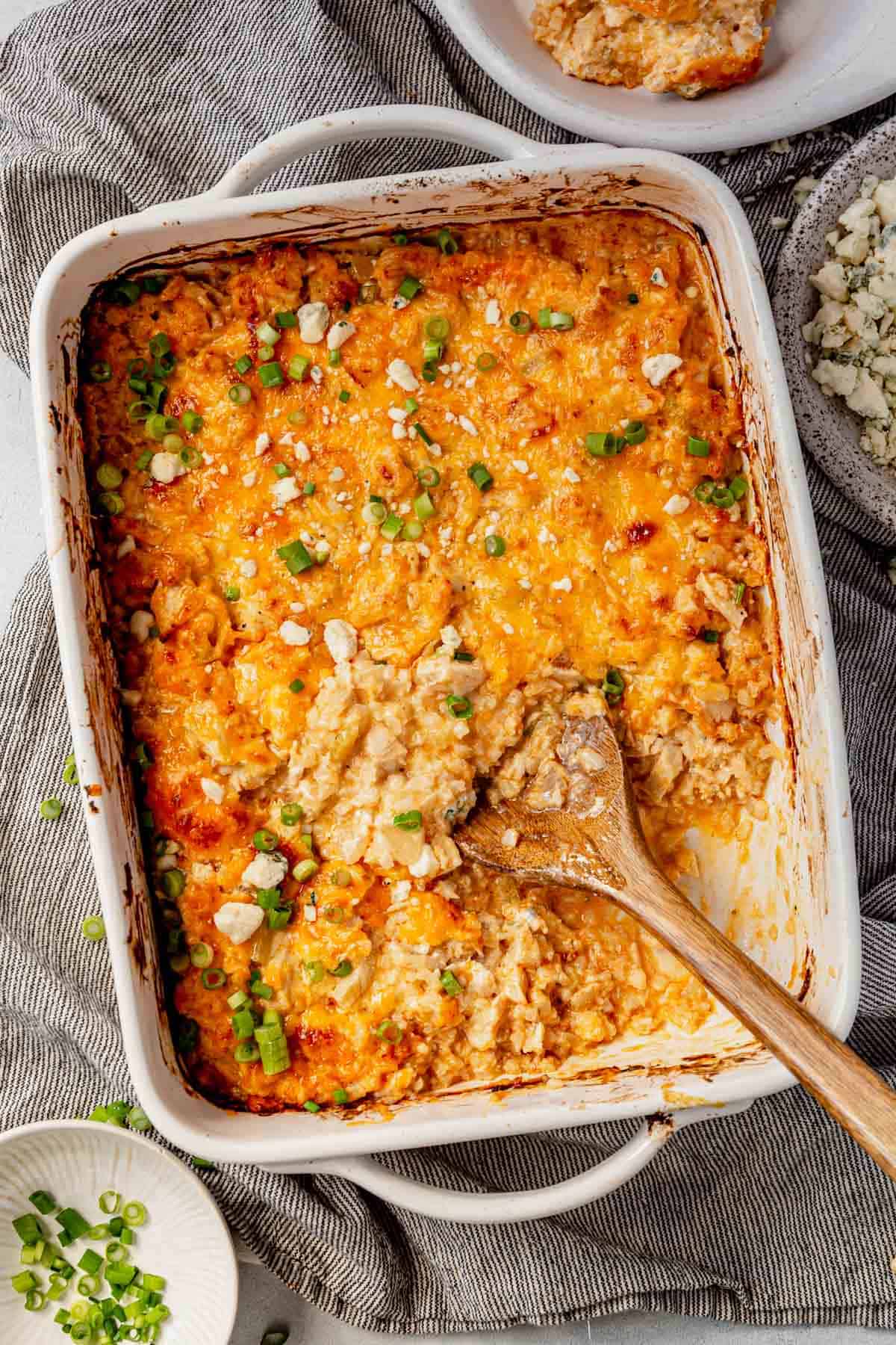 a serving spoon scooping out buffalo chicken casserole from the pan