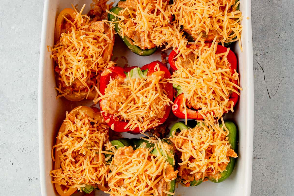 buffalo chicken dip inside raw pepper with shredded cheese on top