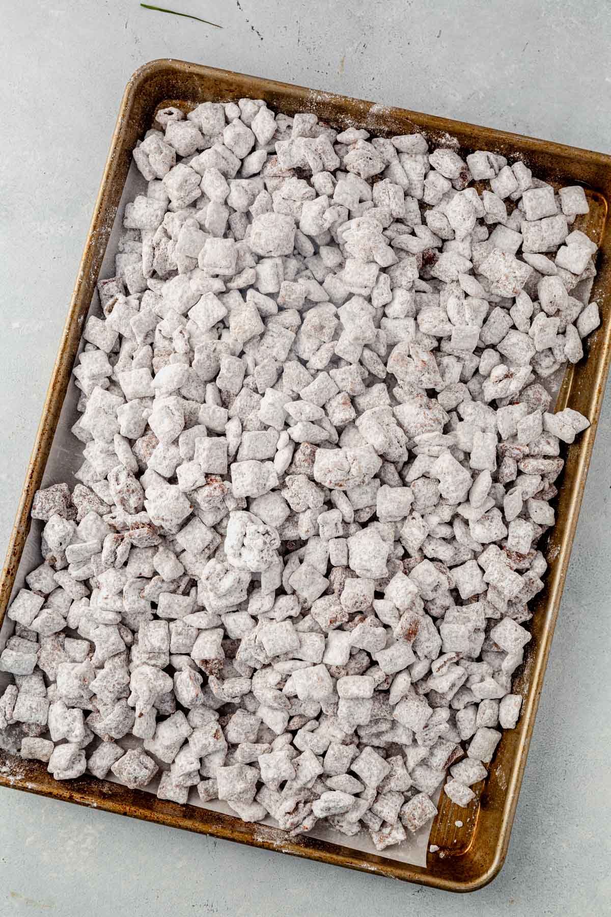 muddy buddies spread out on a sheet pan