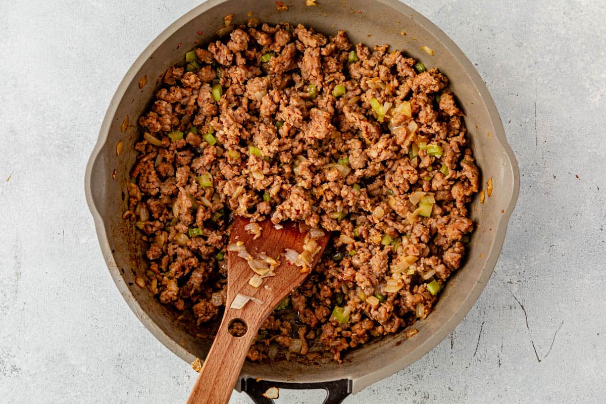 ground sausage, onion, and celery cooked in a skillet