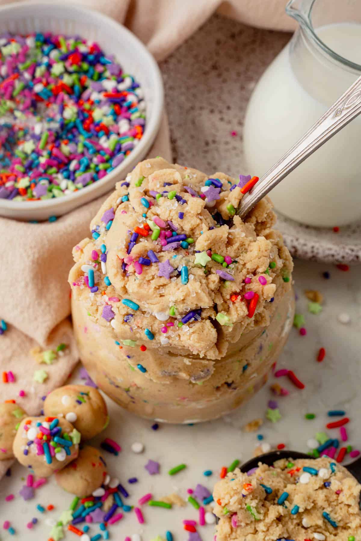 sugar cookie dough in a jar with a bowl of sprinkles