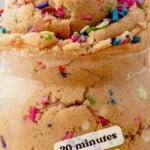 short glass jar filled with eggless edible cookie dough and covered in colorful sprinkles