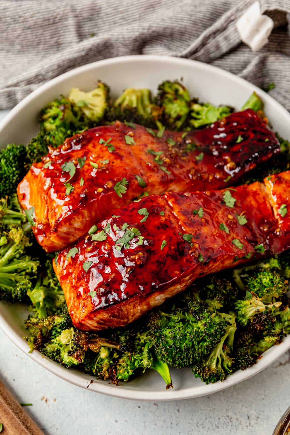 two pieces of honey glazed salmon with roasted broccoli on a plate