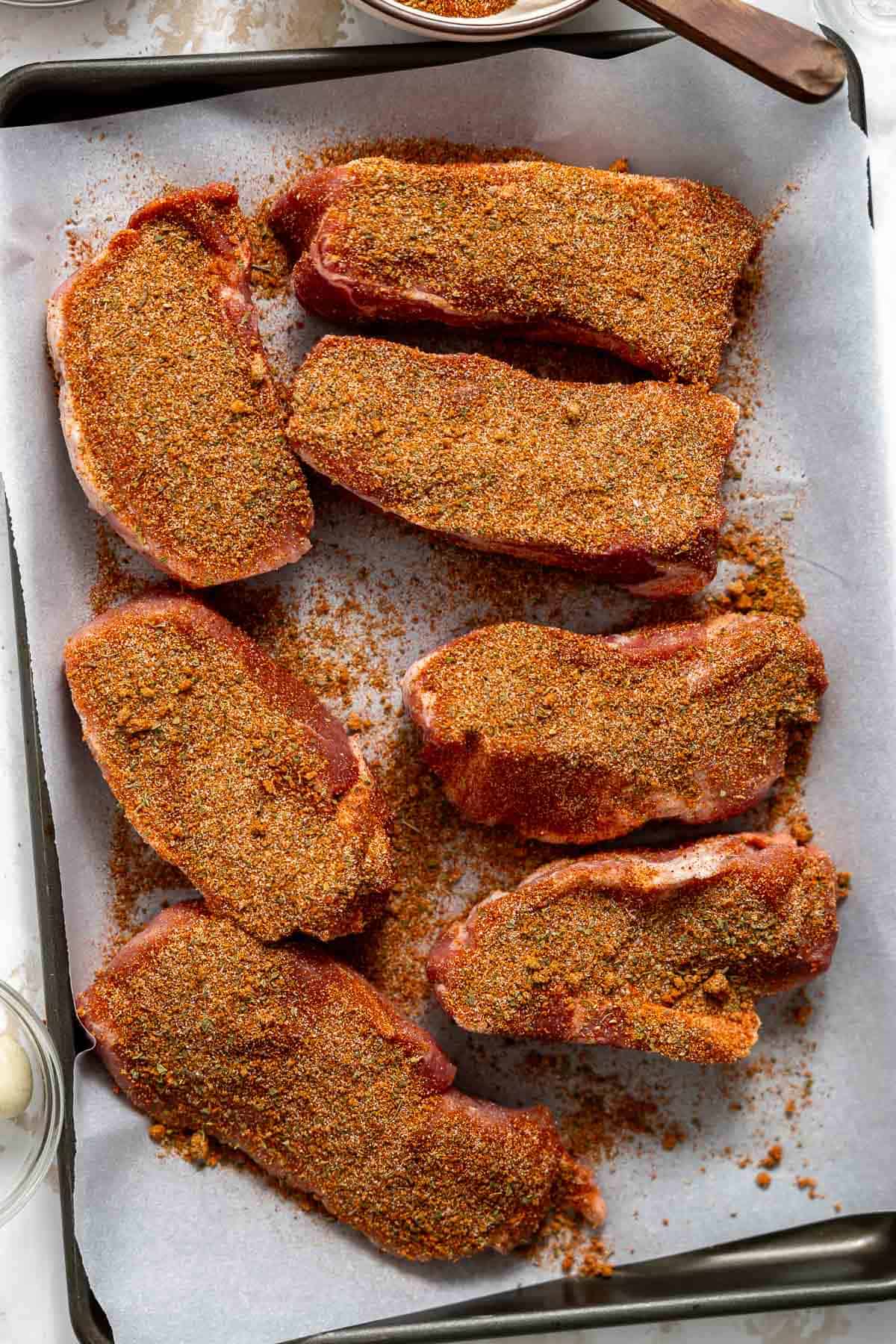 country style ribs coated in dry rub on a baking sheet.