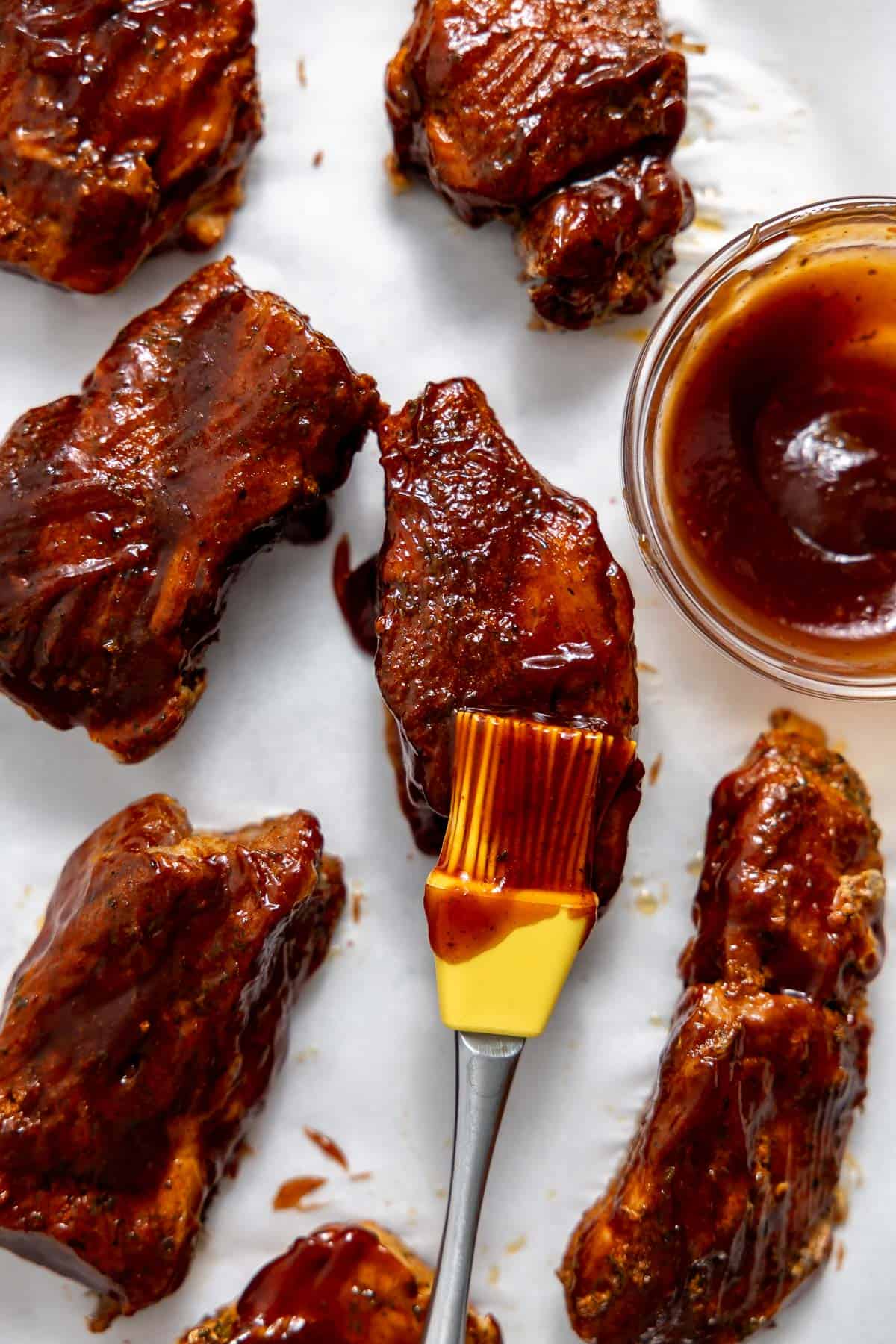 brushing bbq sauce onto boneless pork ribs