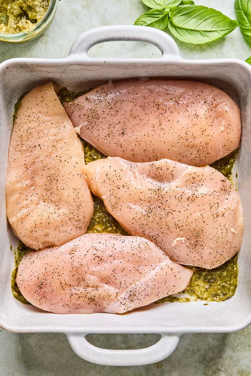 seasoned chicken breasts in a baking dish.