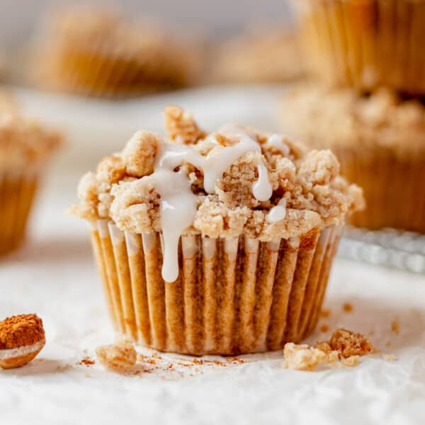 coffee cake muffin with crumb topping on a countertop with icing