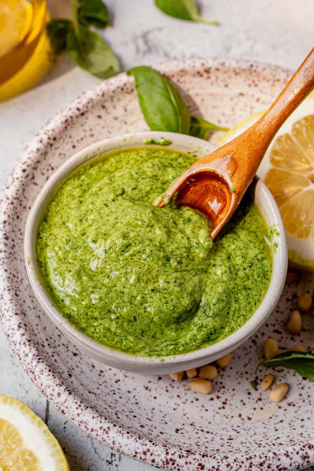a wooden spoon in a bowl of homemade basil pesto