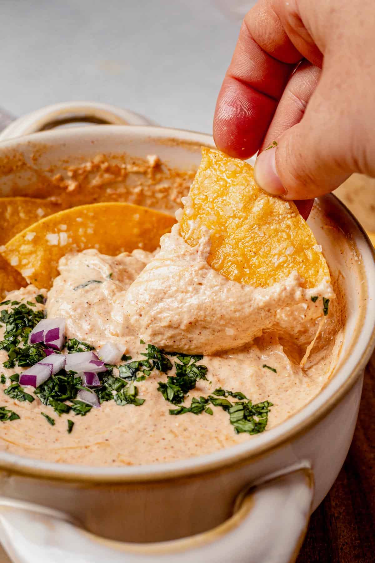 dipping a chip into cottage cheese queso