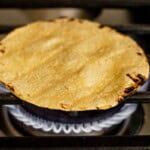 toasting a tortilla on the stove