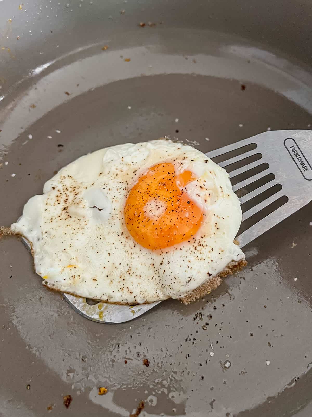 spatula underneath a fried egg before flipping