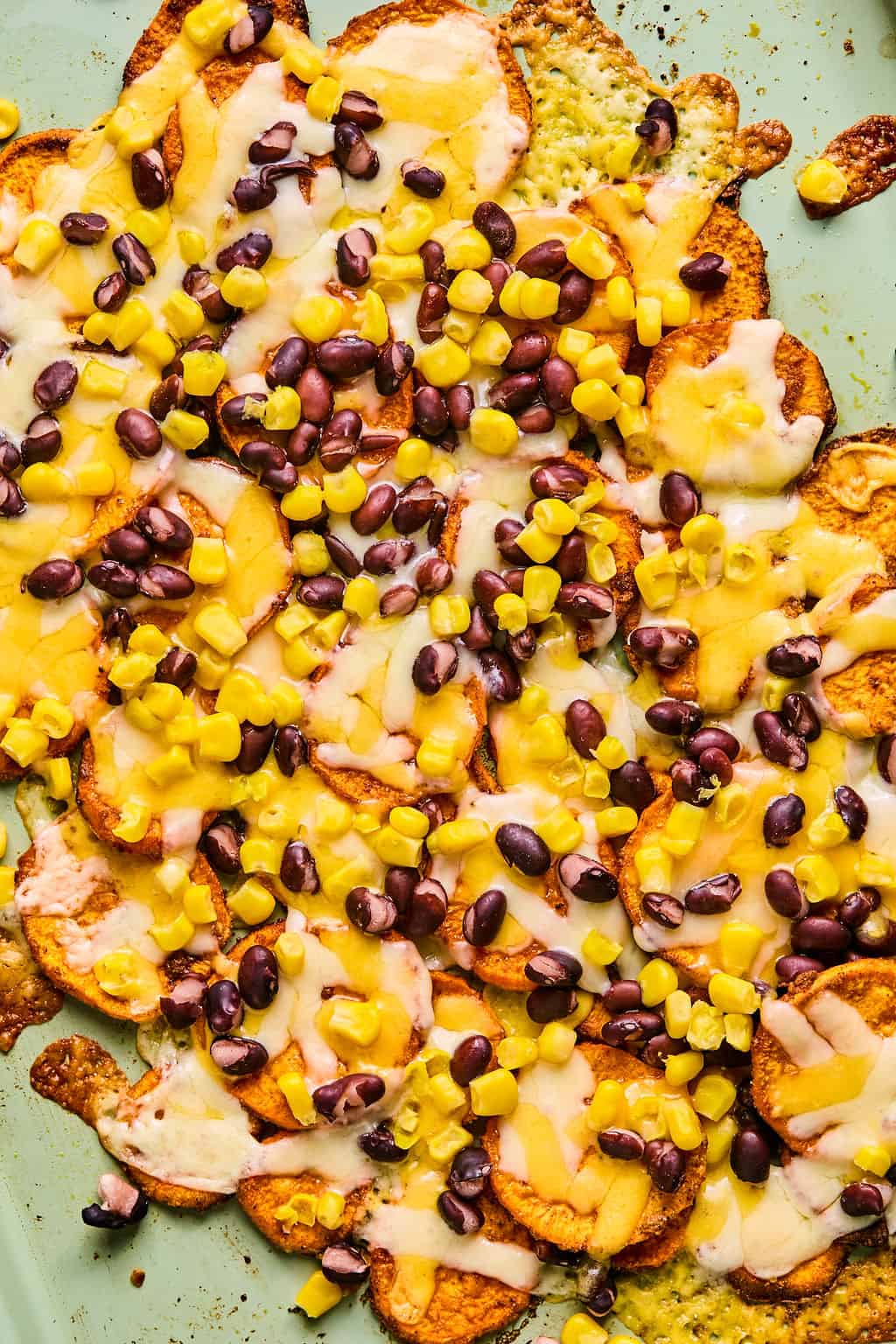 sweet potato nachos topped with melted cheese, black beans, and corn.