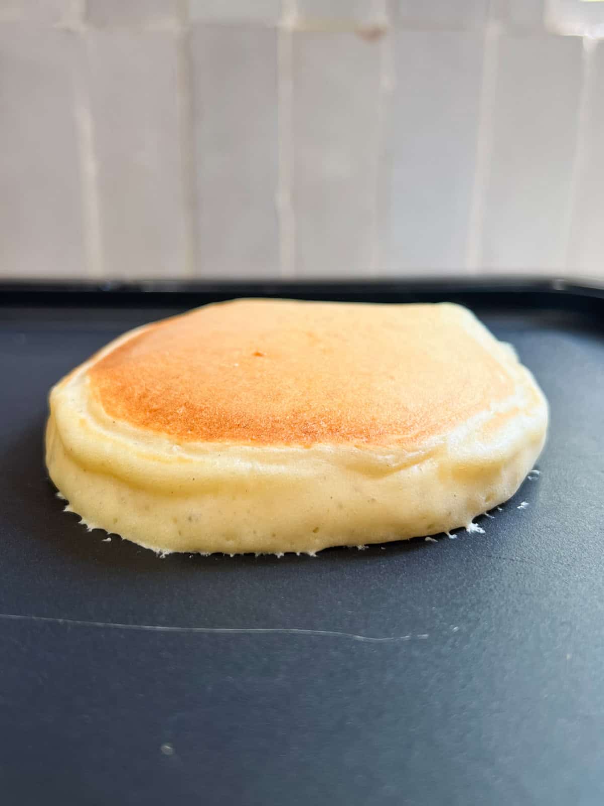 golden brown pancake cooking on a griddle